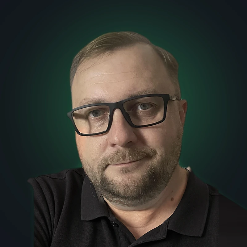 Robert Gęsiarz, konsultant automatyzacji AI, w okularach i czarnej koszulce polo